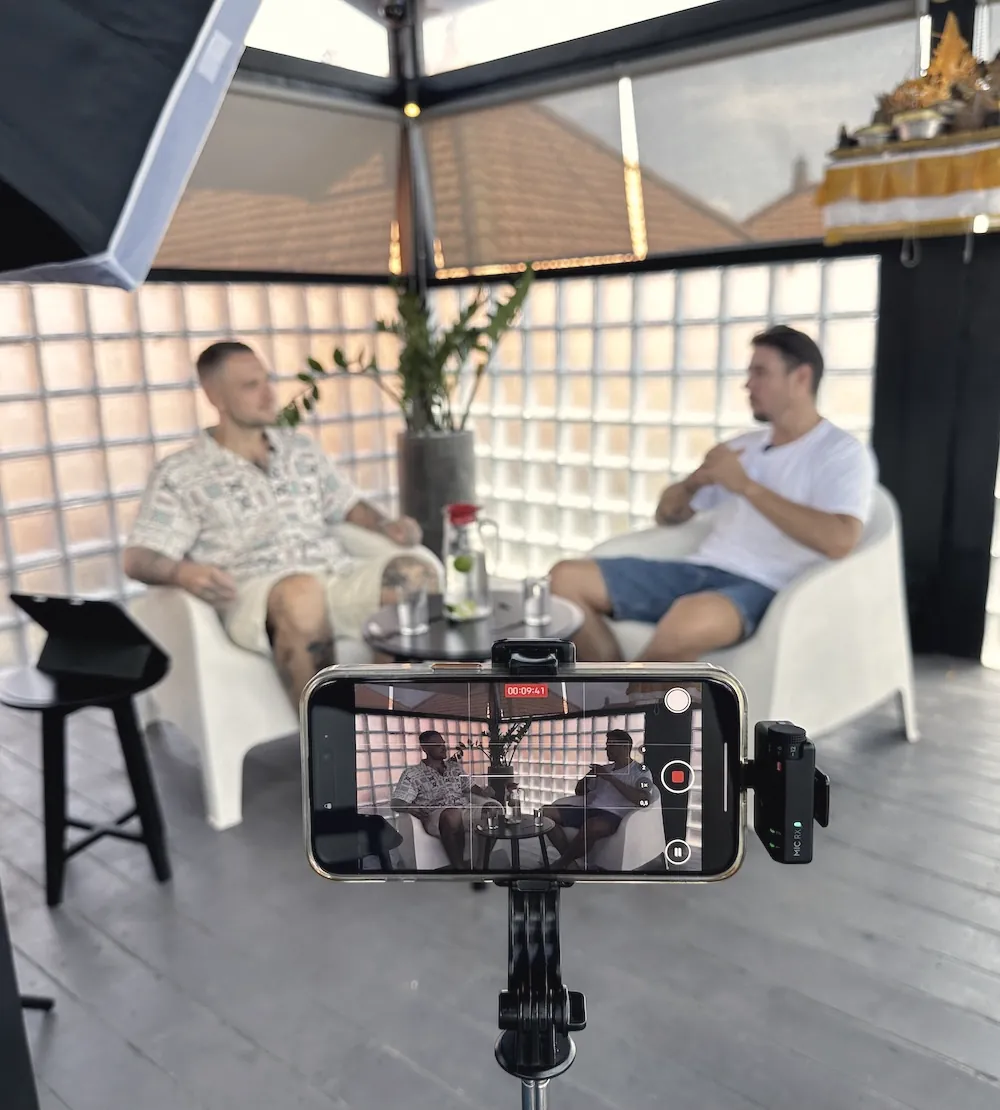 Recording a CHANGES episode in Canggu, Bali, with a phone camera on a tripod in front of two chairs